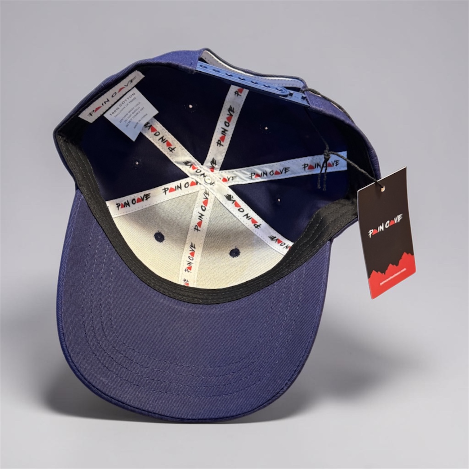 nside view of Pain Cave french navy snapback cap with branded taping and adjustable closure